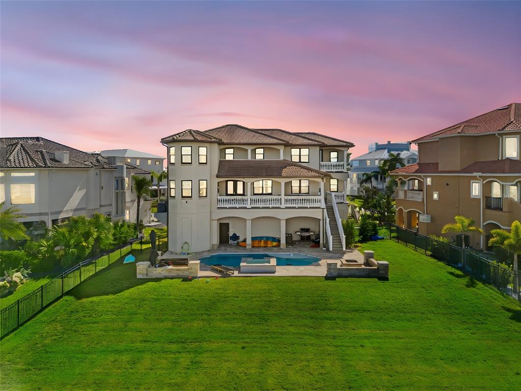 An aerial view of the back of a multi-story house with a pool and lawn — 4387 HARBORPOINTE DRIVE, PORT RICHEY, FL