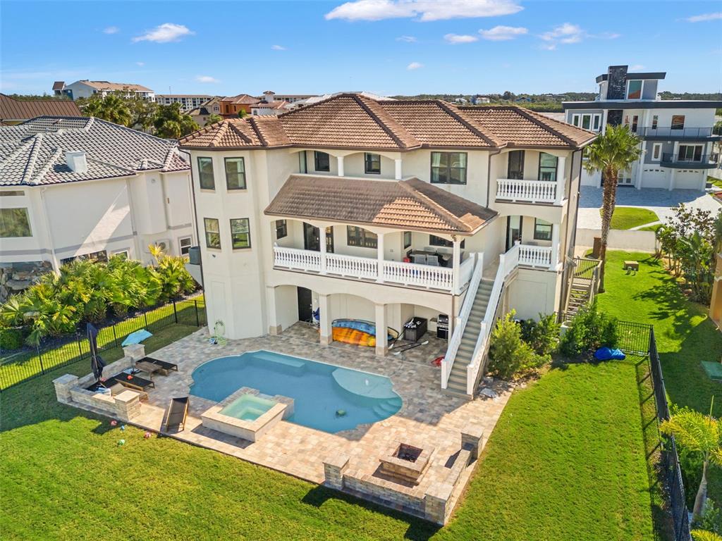 An aerial view shows a multi-story house with a pool, spa, and backyard patio area — 4387 HARBORPOINTE DRIVE, PORT RICHEY, FL