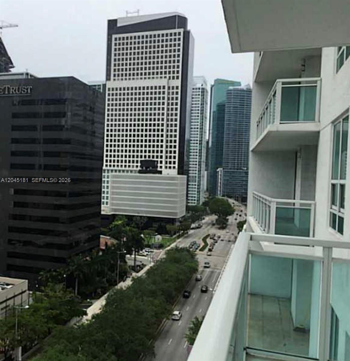 A view from a balcony overlooking a city street with several high-rise buildings — 951 Brickell Ave # 1109, Miami FL 33131, MIAMI, FL