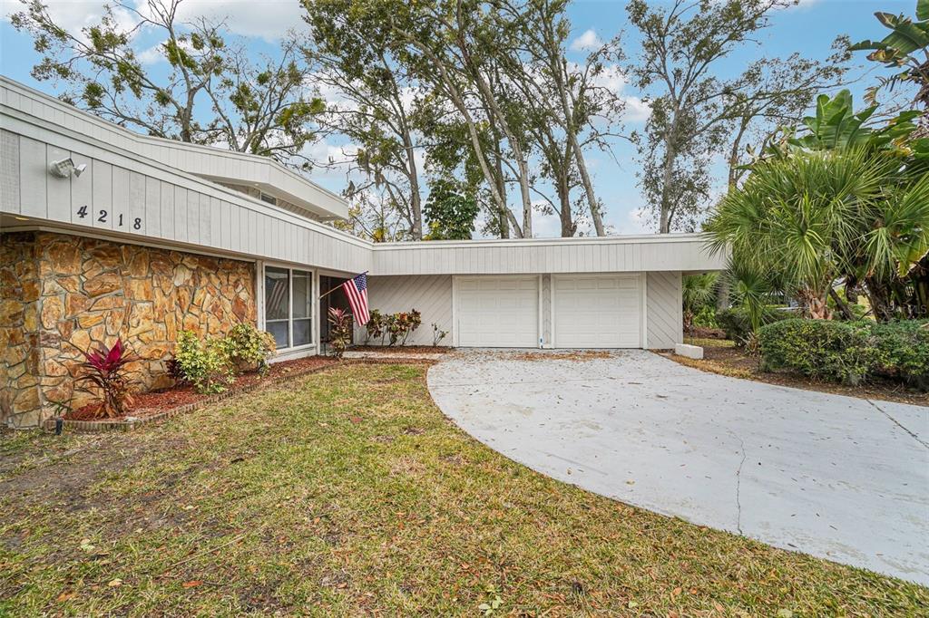 A single-story house features a stone facade, a two-car garage, and a concrete driveway — 4218 WATER OAKS LANE, TAMPA, FL