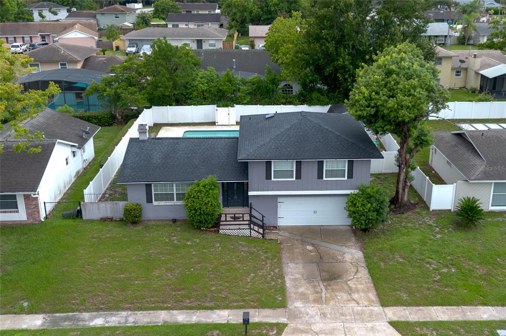 An aerial view of a two-story gray house with a pool and fenced backyard — 103 CASHEW COURT, LONGWOOD, FL