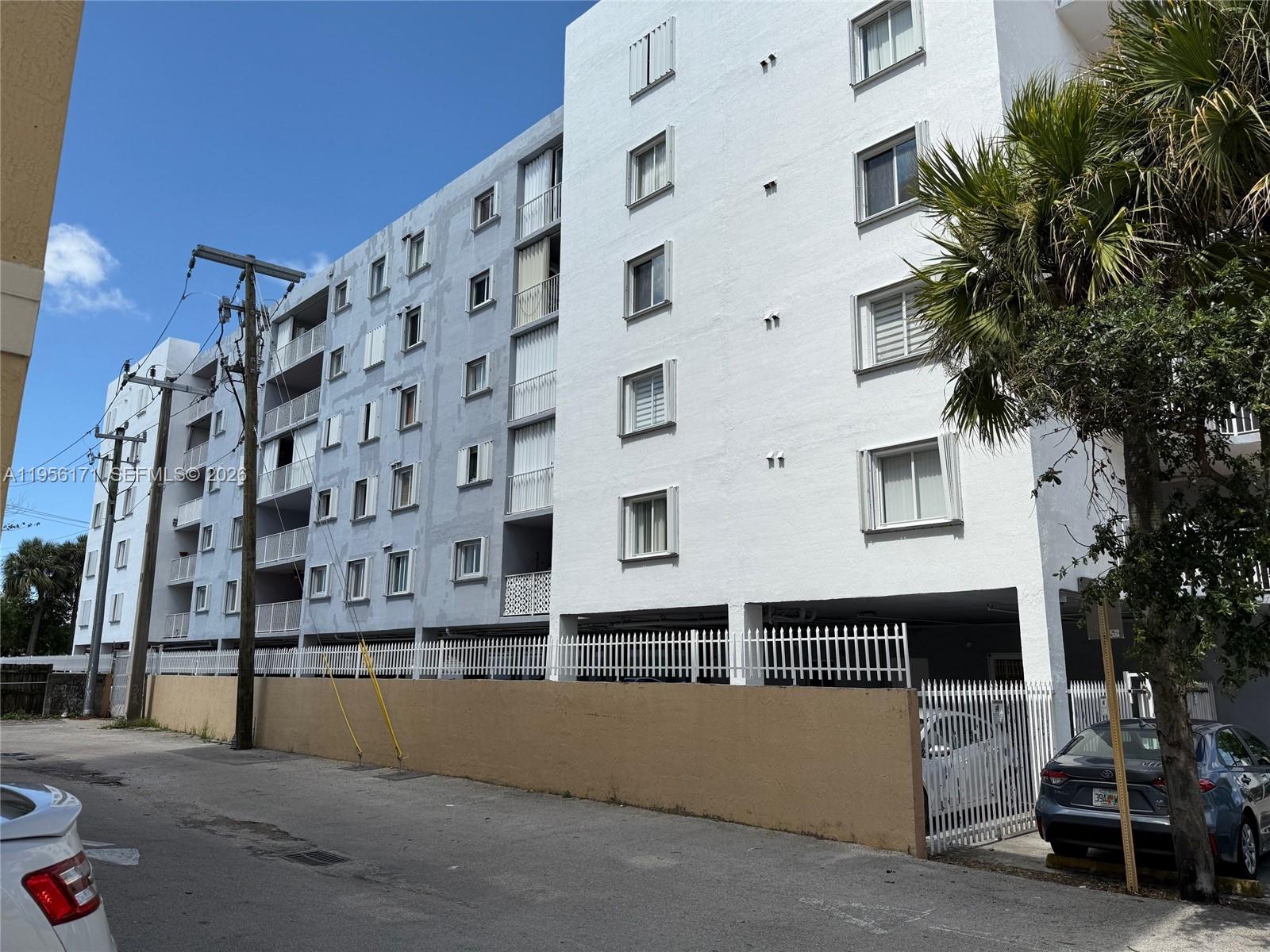 A multi-story apartment building with a white facade and a ground-level parking area — 4854 NW 7th St # 508, Miami FL 33126, MIAMI, FL