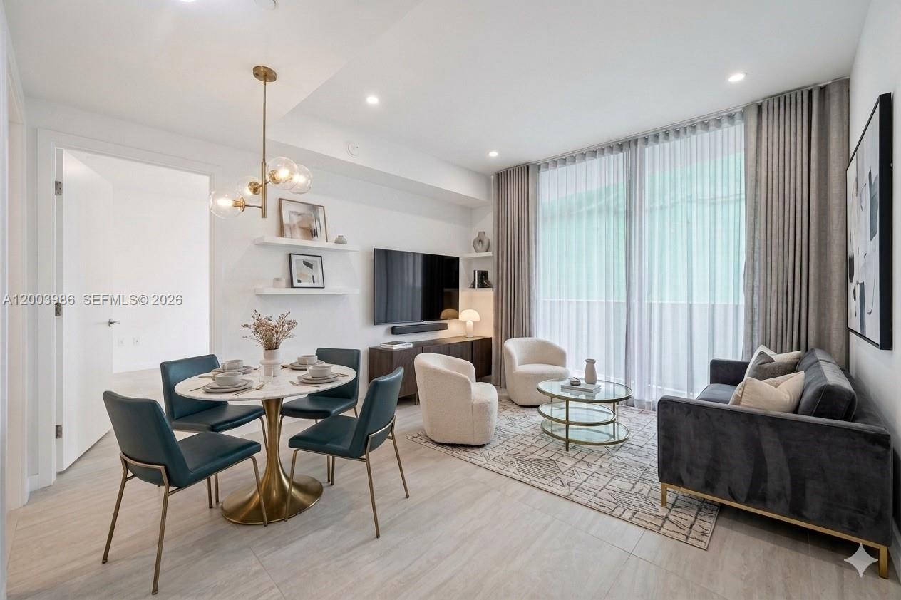A modern living and dining area features a marble table, gray sofa, and floor-to-ceiling curtains — 77 SE 5th Street # 3005, Miami FL 33131, MIAMI, FL