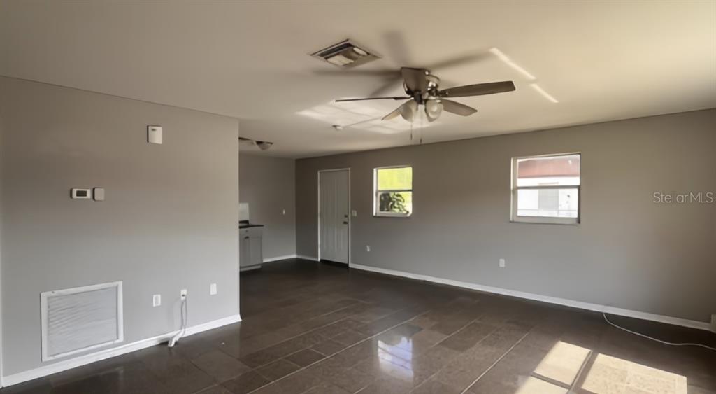 An interior view of a room with gray walls, tile flooring, and a ceiling fan — 1539 PENNY AVENUE, SEBRING, FL