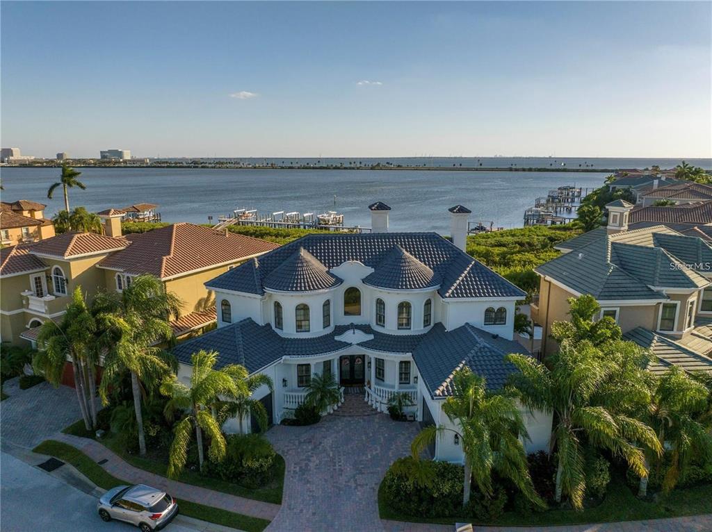 An aerial view of a large, two-story waterfront home with a blue tile roof — 4133 CAUSEWAY VISTA DRIVE, TAMPA, FL