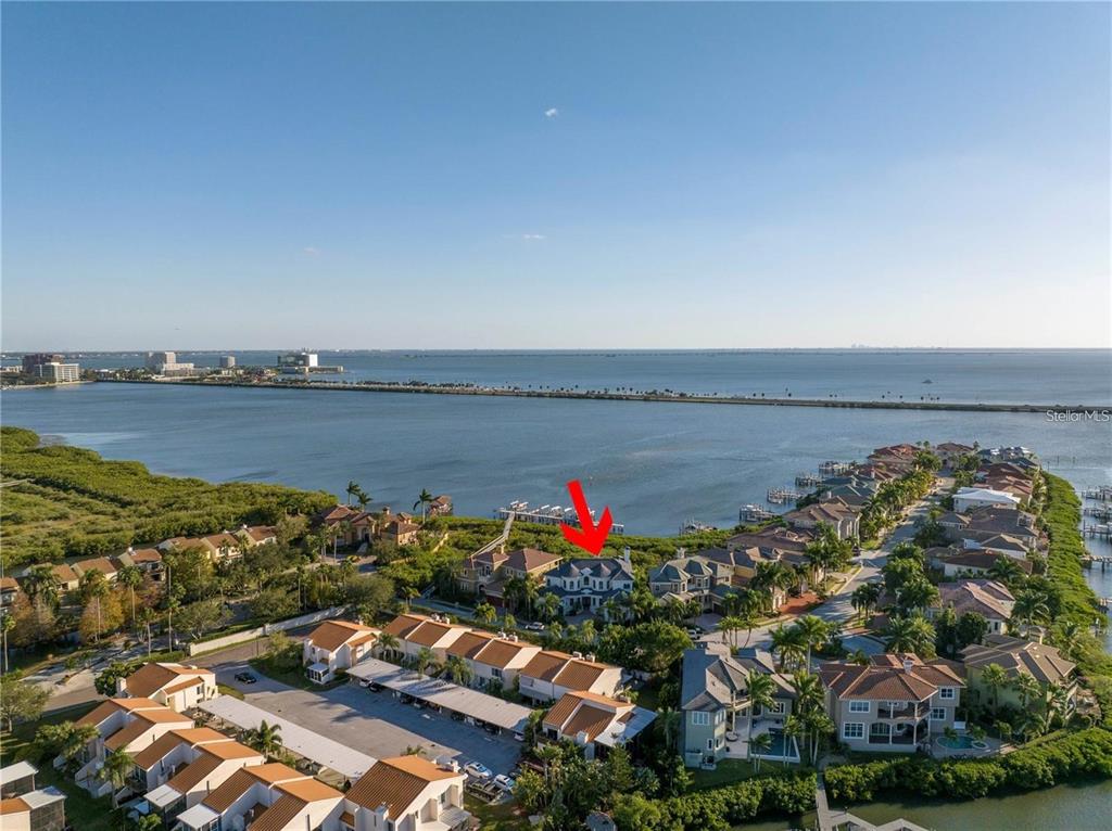 An aerial view shows a waterfront residential neighborhood with a red arrow pointing to a house — 4133 CAUSEWAY VISTA DRIVE, TAMPA, FL