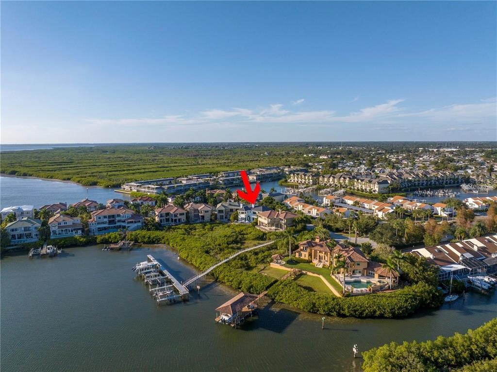 An aerial view shows a waterfront residential neighborhood with a red arrow pointing to a house — 4133 CAUSEWAY VISTA DRIVE, TAMPA, FL