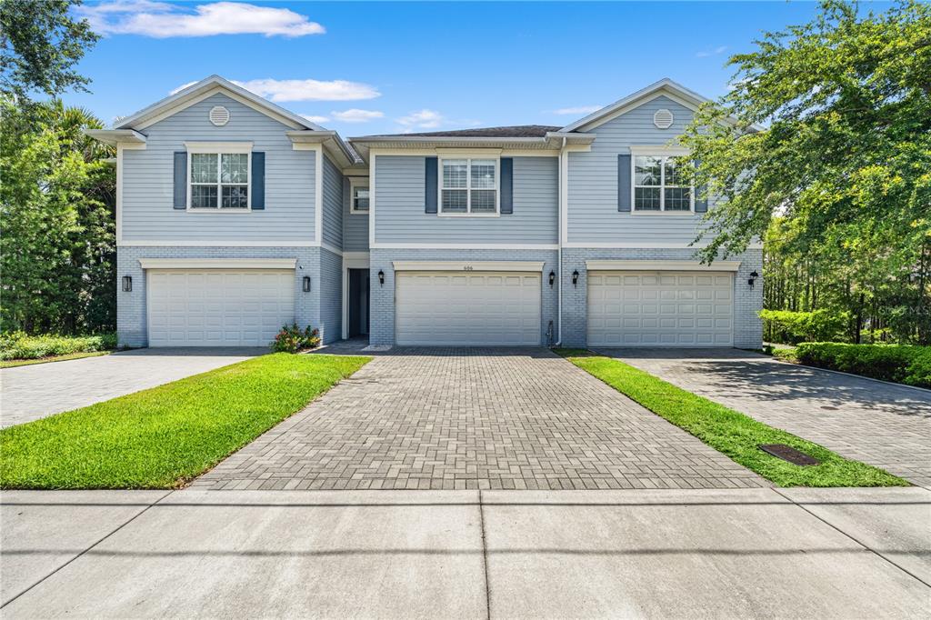 A two-story blue house with three garage doors and a paved driveway — 606 S LINCOLN AVENUE UNIT 2, TAMPA, FL