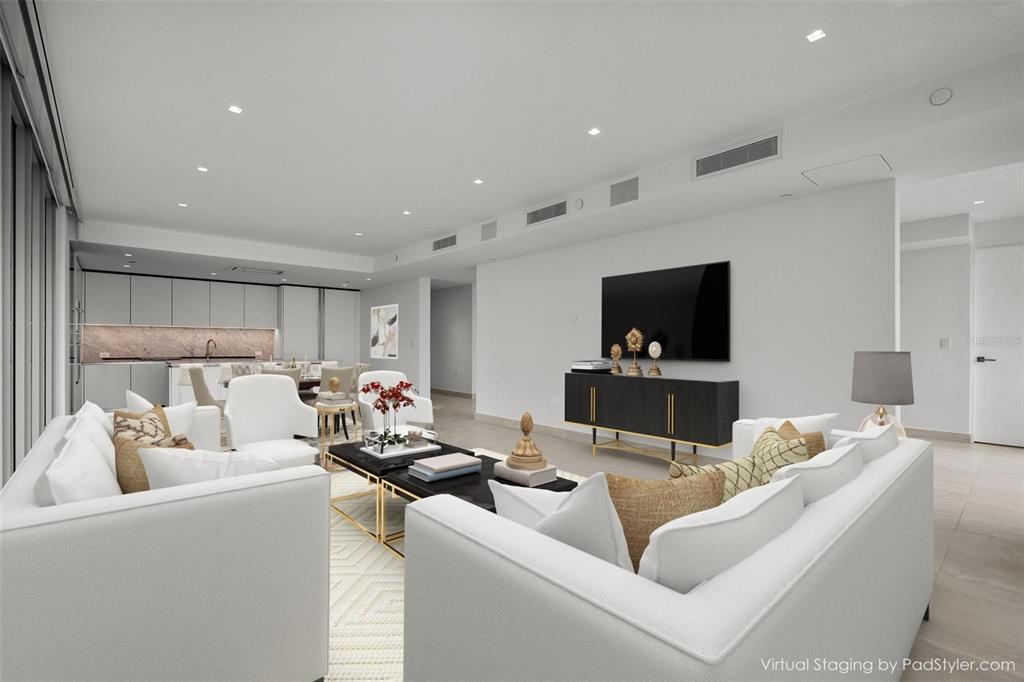 This is a virtually staged living room featuring white sofas, a black media console, and kitchen — 540 DE LA CONSTITUCION AVENUE UNIT 1202, SAN JUAN, PR