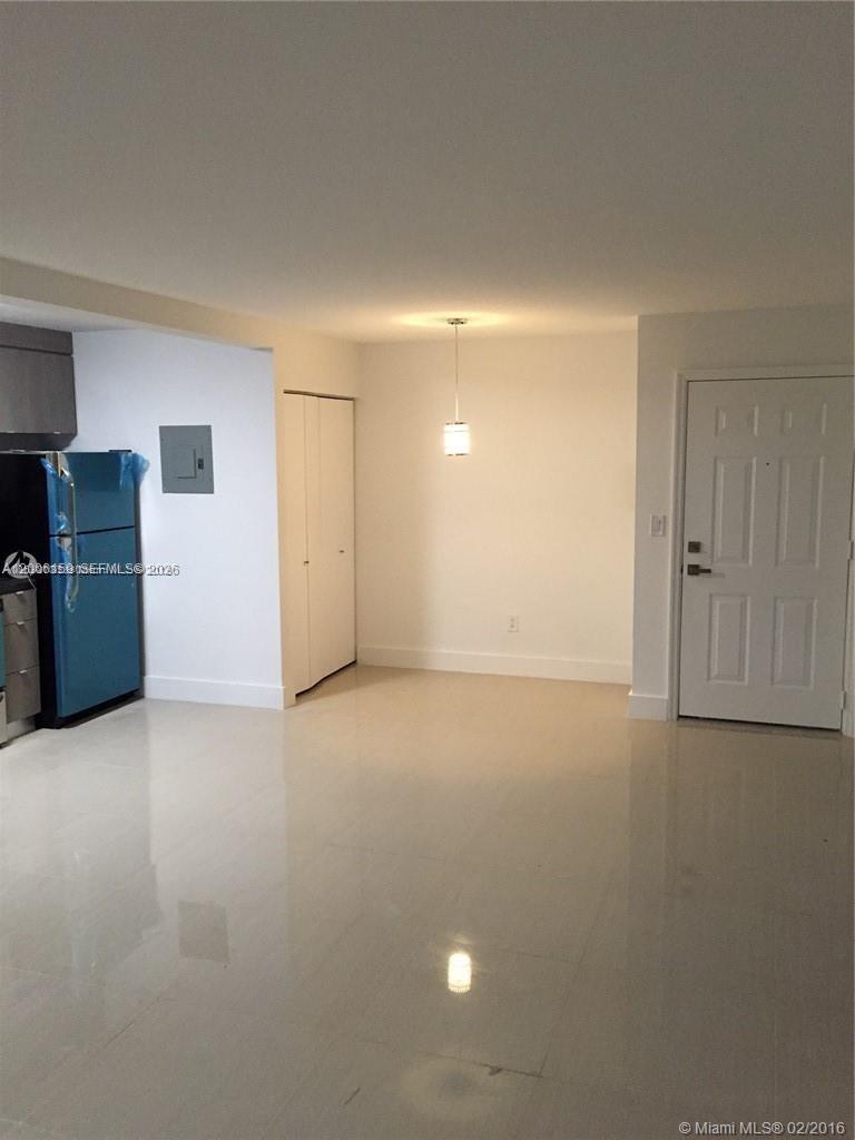 A kitchen and dining area with white walls, tile flooring, and a blue refrigerator — 4110 NW 79th Ave # 1B, Doral FL 33166, DORAL, FL