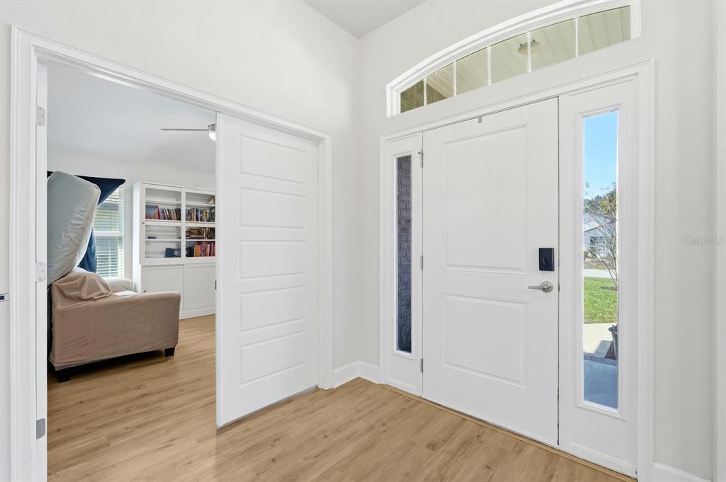 An entryway features a white front door with sidelights, light wood flooring, and an adjacent room — 120 BREN MAR LANE, PALM COAST, FL