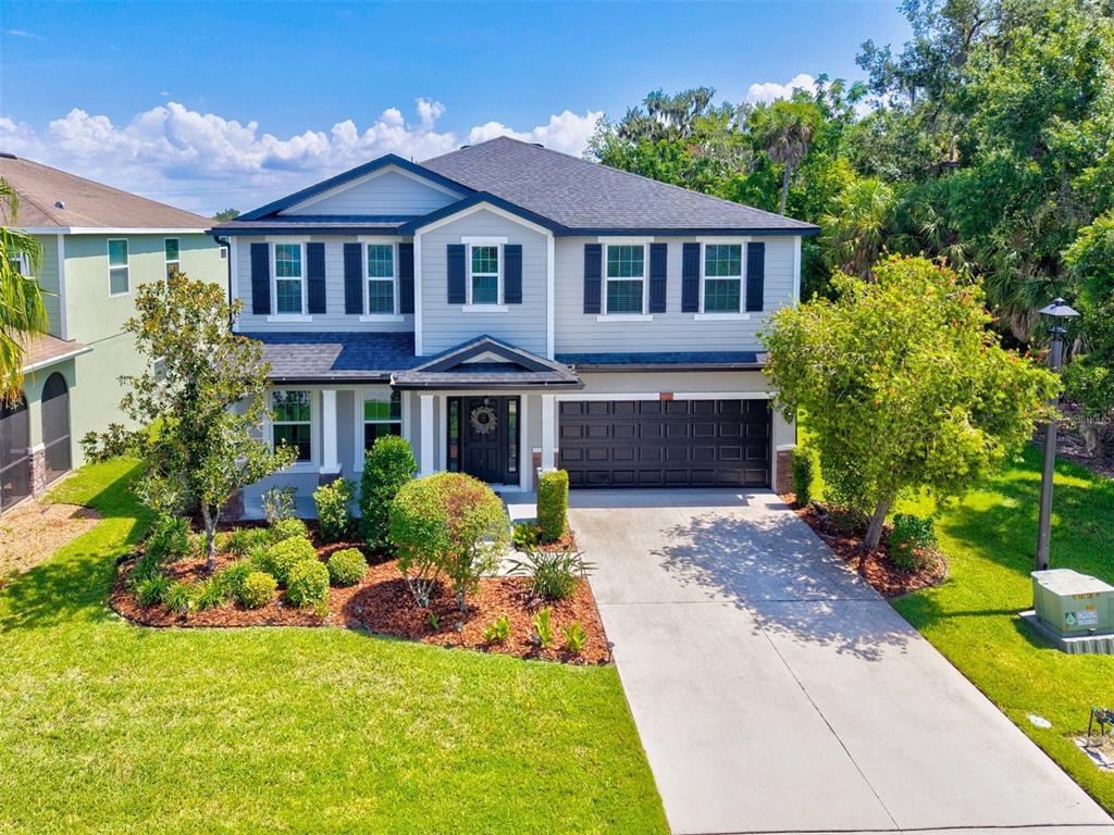 A two-story suburban house with light gray siding, dark shutters, and a two-car garage — 5703 NEW PARIS WAY, ELLENTON, FL