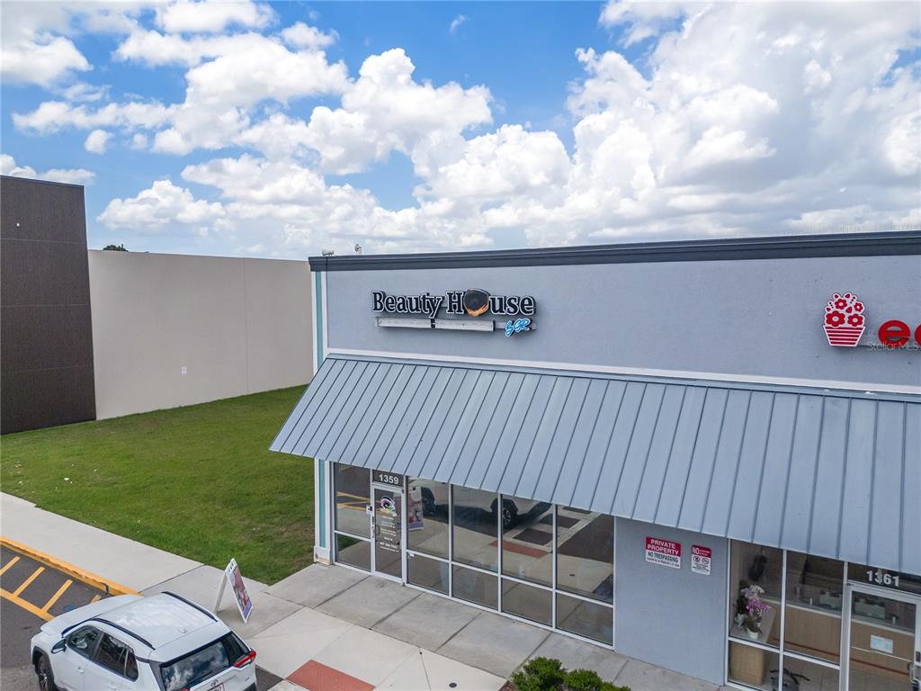 An exterior view of a commercial building storefront with a metal awning and glass windows — 1359 E OSCEOLA PARKWAY, KISSIMMEE, FL
