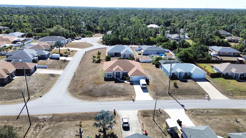 An aerial view shows several suburban houses with driveways and lawns in a wooded neighborhood — 2779 STARVIEW AVENUE, NORTH PORT, FL