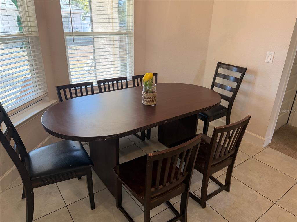 A dining area features a dark wood oval table with four chairs on tiled flooring — 2779 STARVIEW AVENUE, NORTH PORT, FL