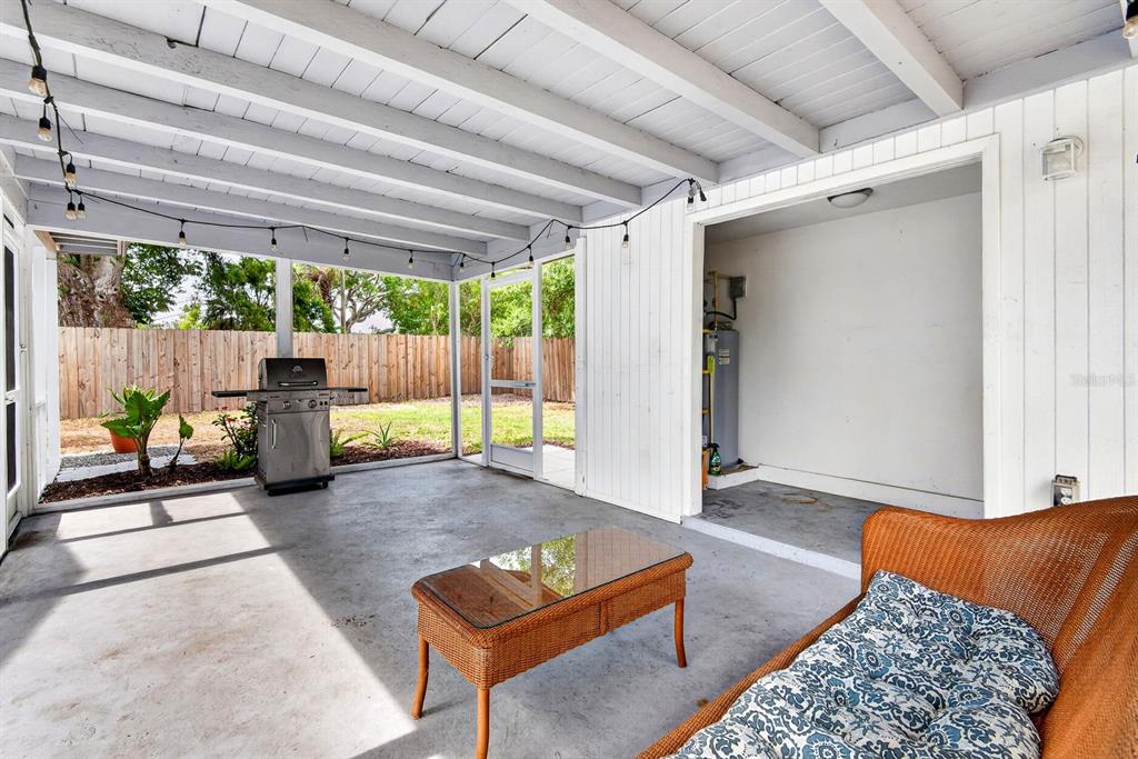 A covered patio features a concrete floor, wicker furniture, a grill, and a utility closet — 916 PATTISON AVENUE, SARASOTA, FL