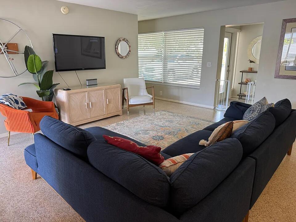A living room features a dark blue sectional sofa, orange accent chair, and television console — 1511 Seabrook Road, Jupiter FL 33469, JUPITER, FL