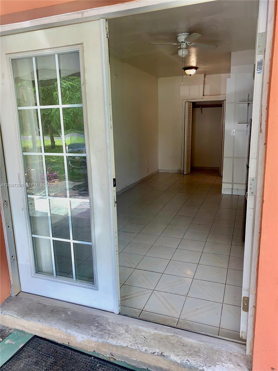 A view through an open glass door into a tiled room with a ceiling fan — 13140 N Miami Ave # 1, Miami FL 33168, MIAMI, FL