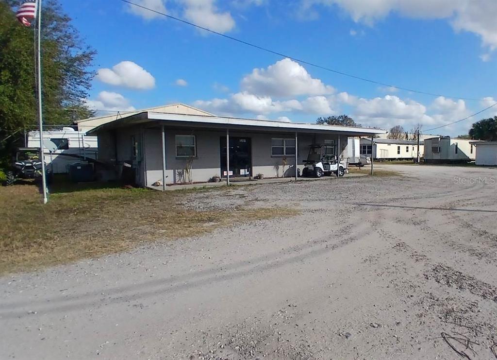 A single-story commercial building with a covered porch sits on a gravel lot — 2295 US HIGHWAY 92 E, PLANT CITY, FL