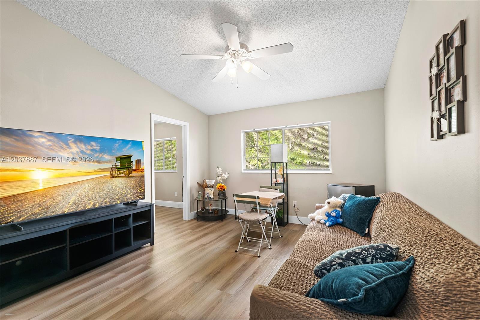A living room features wood-look flooring, a ceiling fan, a television, and a small dining area — 3690 N 56th Ave # 948, Hollywood FL 33021, HOLLYWOOD, FL