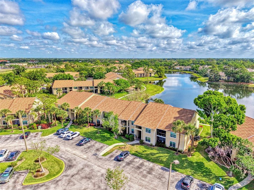 An aerial view of a multi-story apartment complex with a lake and parking lot — 4045 CROCKERS LAKE BOULEVARD UNIT 11, SARASOTA, FL