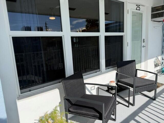 Two black wicker chairs sit on a patio outside a room with large windows — 1110 N Riverside Drive # 25, Pompano Beach FL 33062, POMPANO BEACH, FL