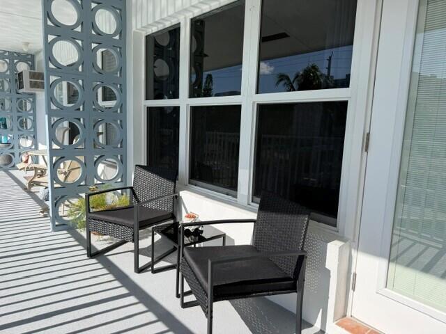 A patio features two black wicker chairs, a small side table, and decorative screen blocks — 1110 N Riverside Drive # 25, Pompano Beach FL 33062, POMPANO BEACH, FL