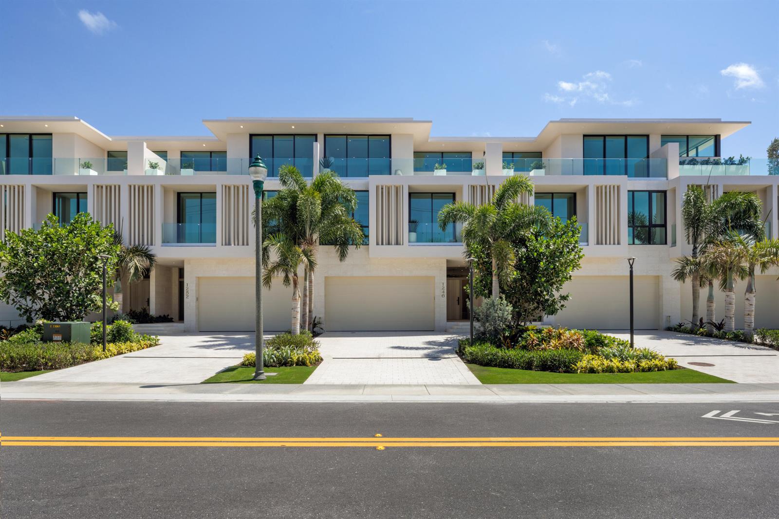 A modern multi-unit residential building with beige stone facades, glass balconies, and palm trees — 1258 George Bush Boulevard, Delray Beach FL 33483, DELRAY BEACH, FL