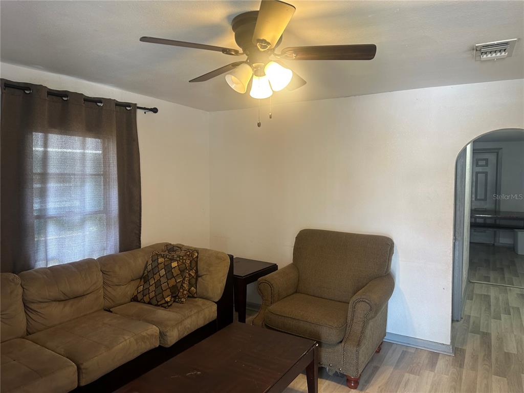 A living room features a brown sofa, an armchair, a coffee table, and a ceiling fan — 4506 N 42ND STREET, TAMPA, FL