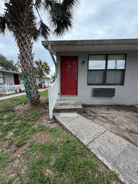 A single-story exterior view shows a red front door labeled 33 and a palm tree — 1400 STRAWBERRY PLACE UNIT 33, PLANT CITY, FL