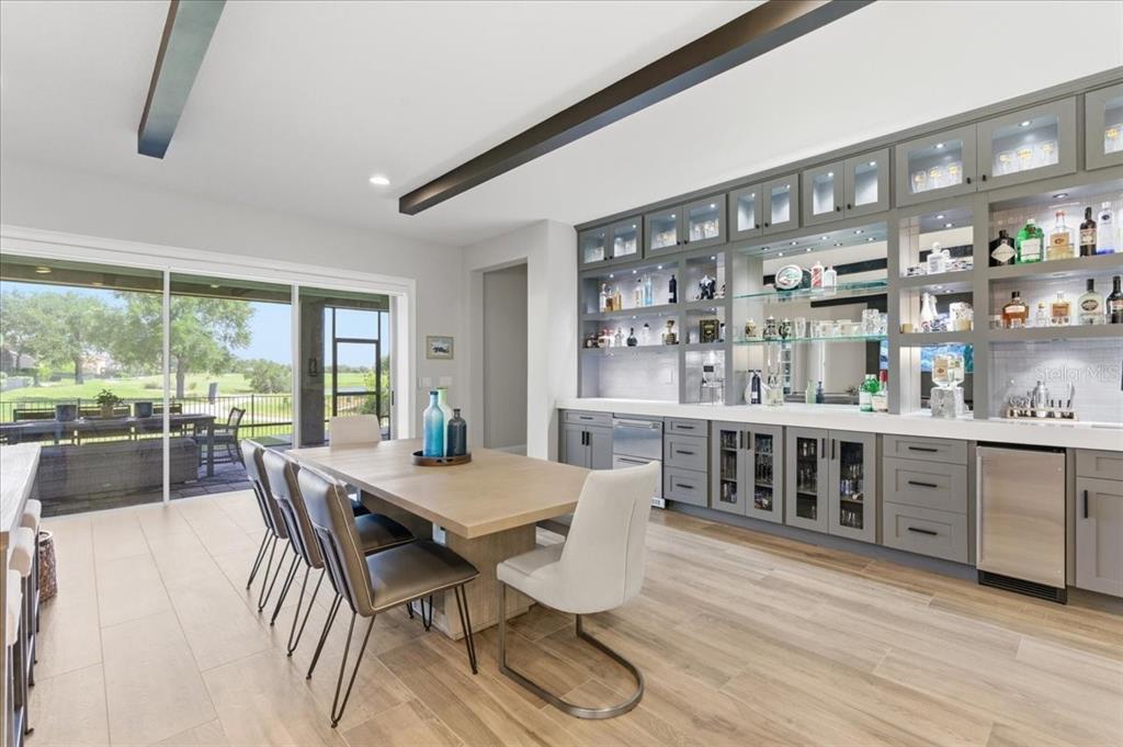 A dining room features a large wooden table, gray cabinetry, and a sliding glass door — 10123 BUCKLOW HILL DRIVE, ORLANDO, FL