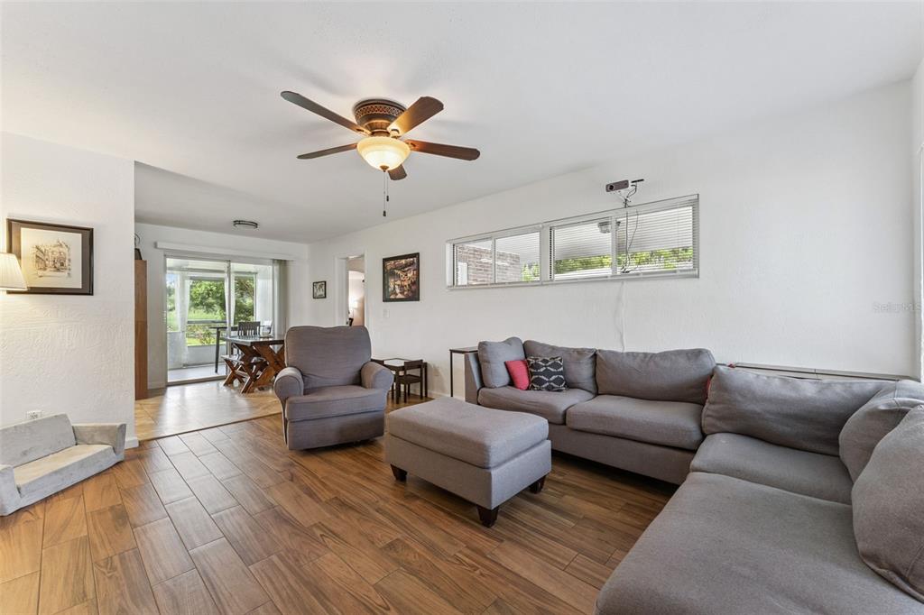 A living room features wood-look tile flooring, a gray sectional sofa, and a ceiling fan — 812 AGNES DRIVE, ALTAMONTE SPRINGS, FL