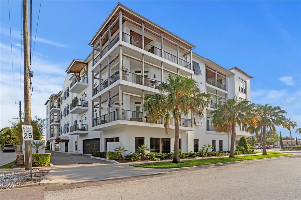 A covered balcony features wooden support beams, string lights, and a view of the sunset — 91 DAVIS BOULEVARD UNIT 303, TAMPA, FL