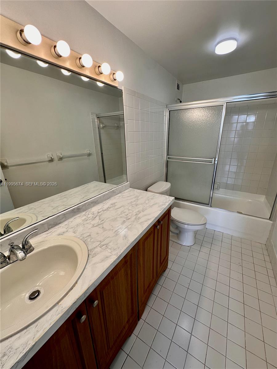 A bathroom features a wood vanity with a marble-look countertop, a mirror, and a tub-shower — 3301 NE 5th Ave # 618, Miami FL 33137, MIAMI, FL