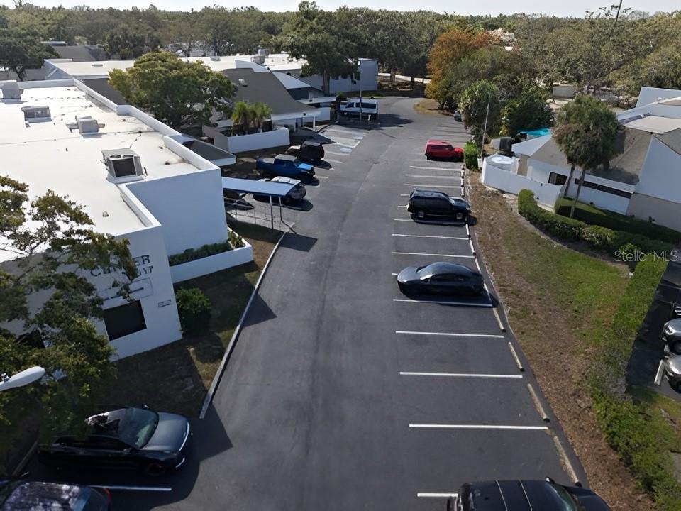 An aerial view shows a parking lot with several cars parked next to a building — 617 LAKEVIEW ROAD UNIT A, CLEARWATER, FL