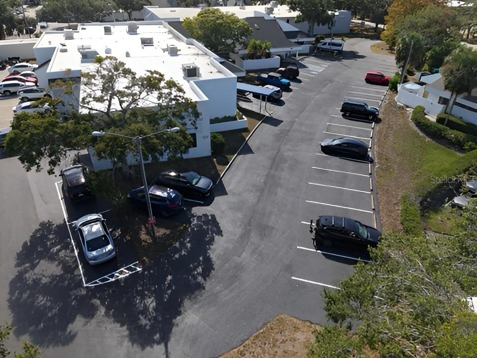 An aerial view shows a commercial building with a parking lot and surrounding trees — 617 LAKEVIEW ROAD UNIT A, CLEARWATER, FL