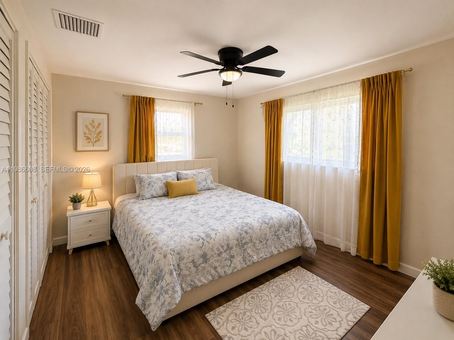 A bedroom features a bed with floral bedding, mustard curtains, and a ceiling fan — 1507 Harding St, Hollywood FL 33020, HOLLYWOOD, FL