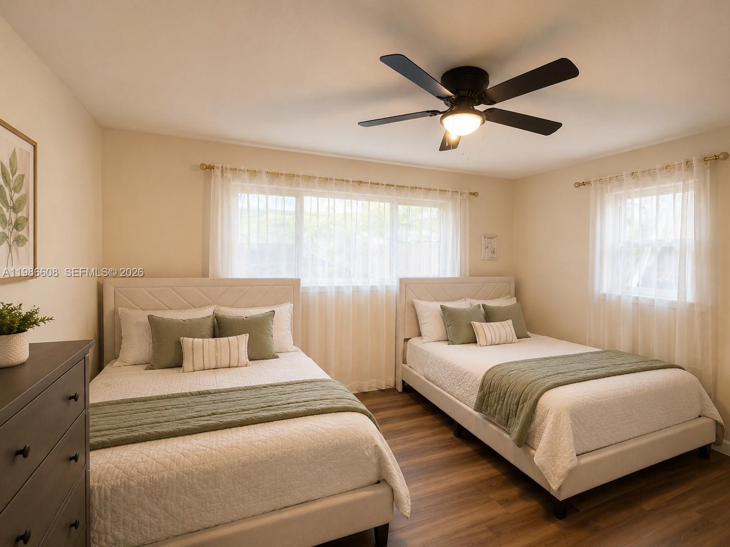 A bedroom features two beds with white bedding, green accents, and a ceiling fan — 1507 Harding St, Hollywood FL 33020, HOLLYWOOD, FL