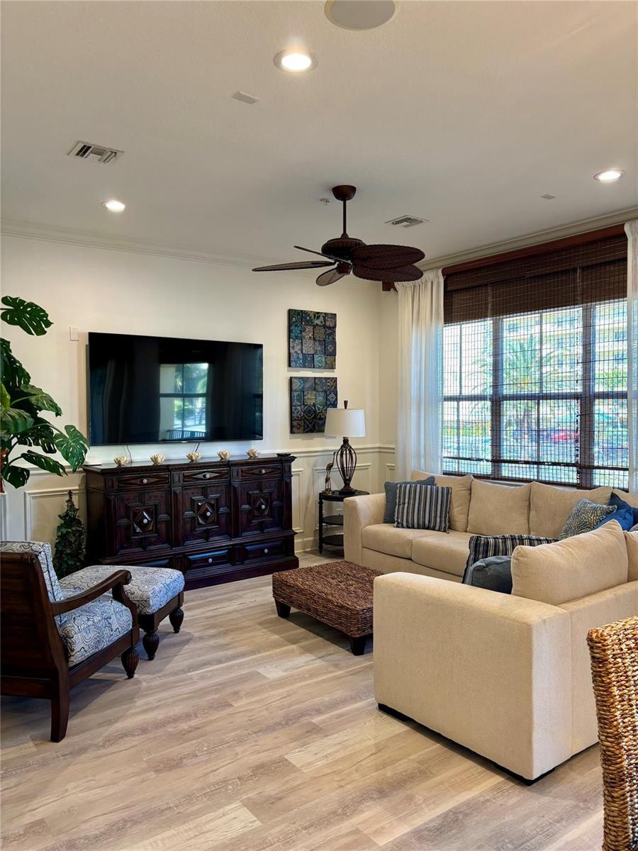 A living room features a dark wood media console, beige sectional sofa, and ceiling fan — 126 Ocean Bay Drive, Jensen Beach FL 34957, JENSEN BEACH, FL