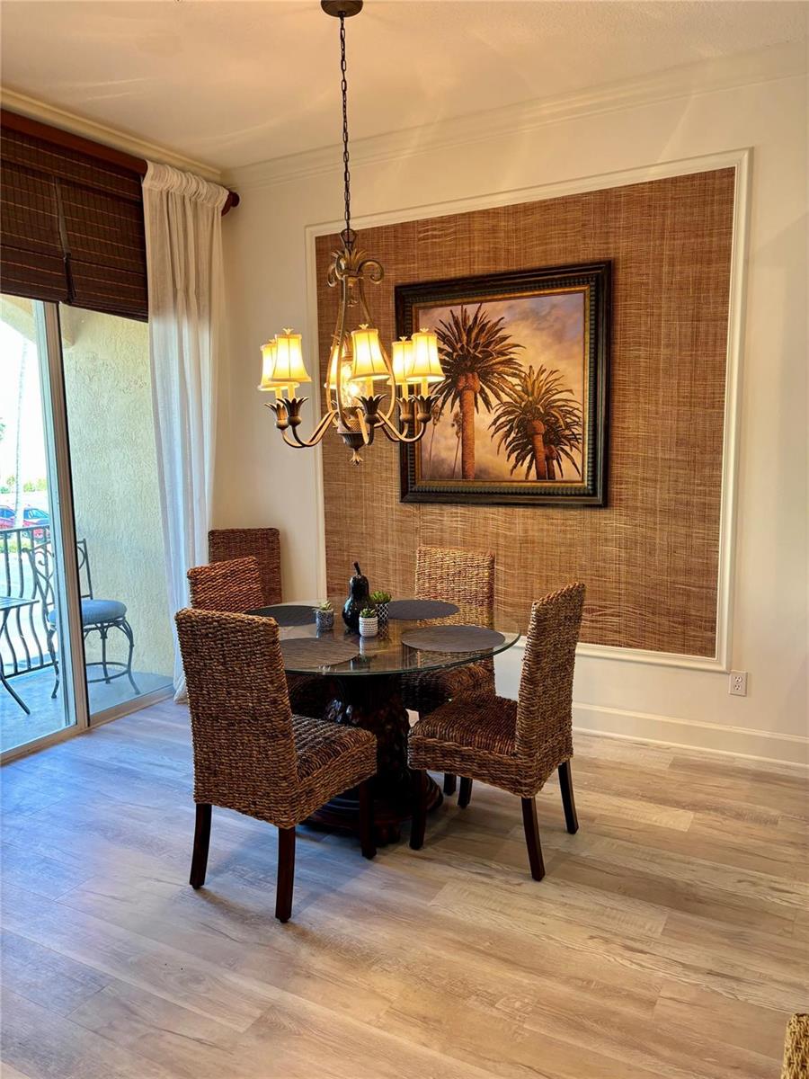 A dining area features a glass-topped table, woven chairs, and a textured accent wall — 126 Ocean Bay Drive, Jensen Beach FL 34957, JENSEN BEACH, FL