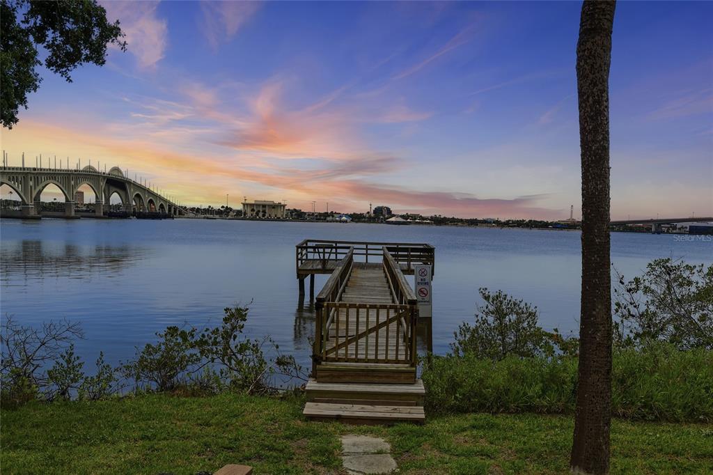 A wooden pier extends into a calm body of water with a bridge in the distance — 944 S PENINSULA DRIVE UNIT 5010, DAYTONA BEACH, FL
