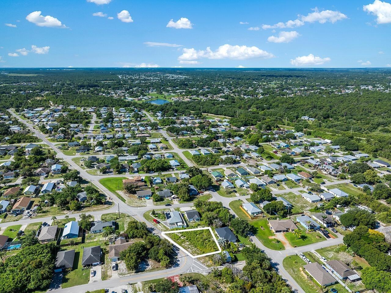 An aerial view shows a vacant, grass-covered corner lot outlined in white within a residential neighborhood — 1325 2nd Road SW, Vero Beach FL 32962, VERO BEACH, FL