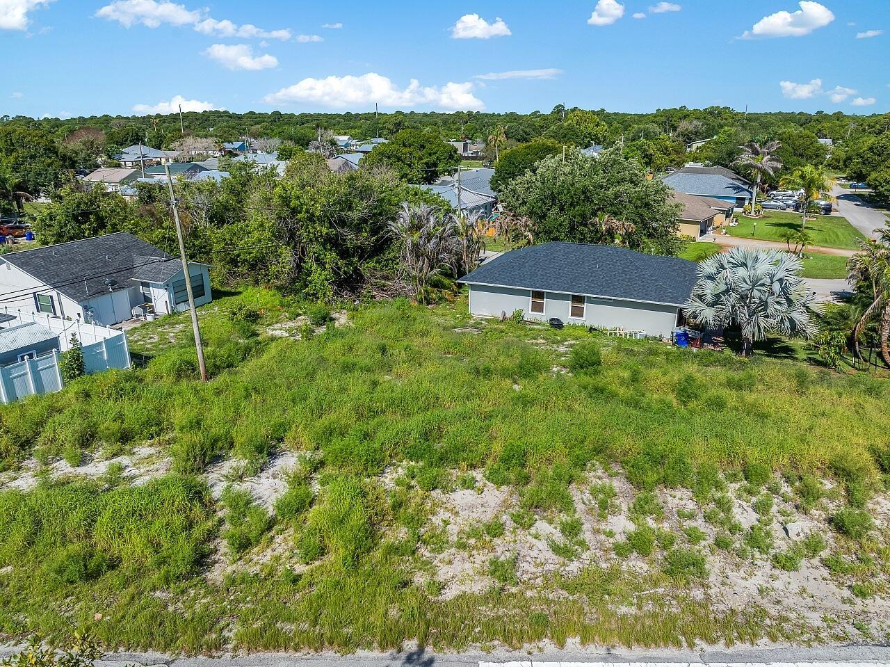 An elevated view of a vacant, grass-covered lot situated between two residential houses — 1325 2nd Road SW, Vero Beach FL 32962, VERO BEACH, FL