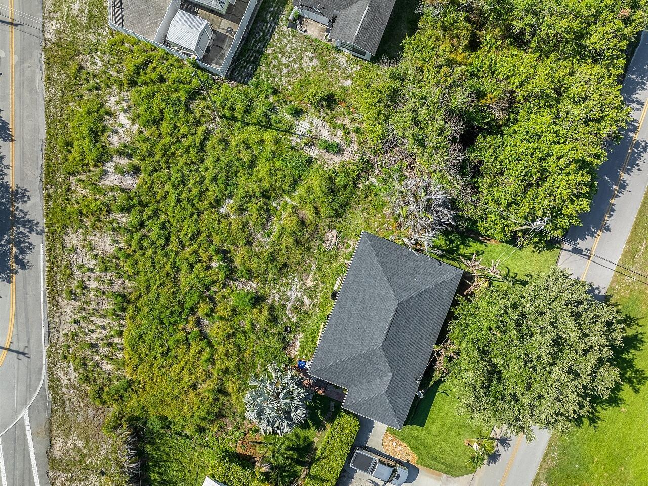 An aerial view shows a house with a dark roof surrounded by trees and vegetation — 1325 2nd Road SW, Vero Beach FL 32962, VERO BEACH, FL
