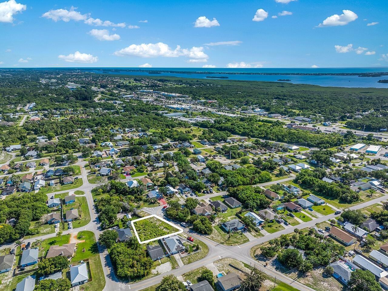 An aerial view shows a vacant, grass-covered residential lot outlined in white within a neighborhood — 1325 2nd Road SW, Vero Beach FL 32962, VERO BEACH, FL