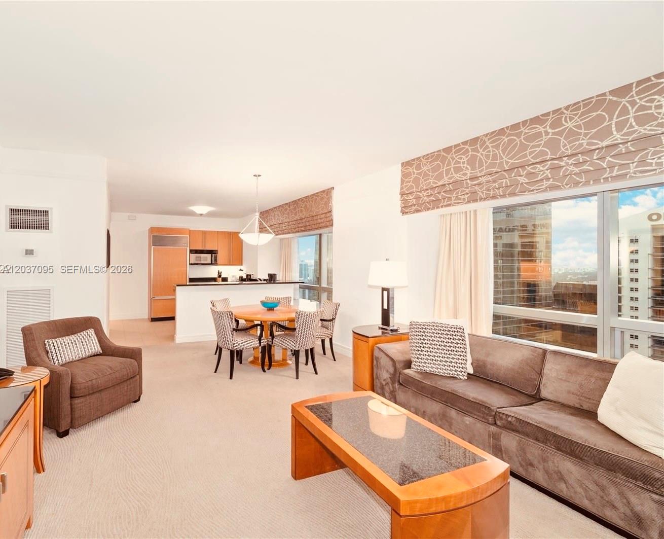 This living and dining area features a brown sofa, a round table, and floor-to-ceiling windows — 1435 Brickell Ave # 3412, Miami FL 33131, MIAMI, FL