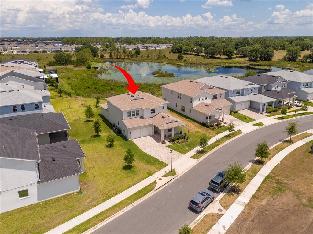 An aerial view shows a two-story suburban house with a paved driveway near a pond — 13181 TOOLCROSS WAY, WINTER GARDEN, FL