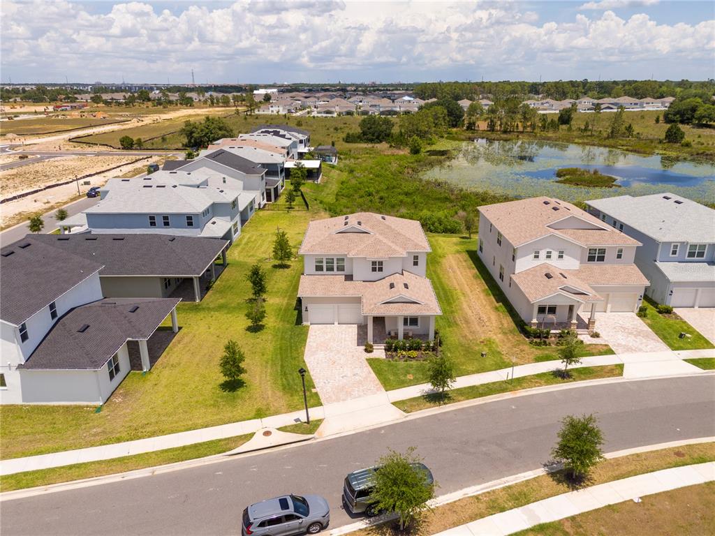 An aerial view shows a suburban neighborhood with several houses, a pond, and a street — 13181 TOOLCROSS WAY, WINTER GARDEN, FL