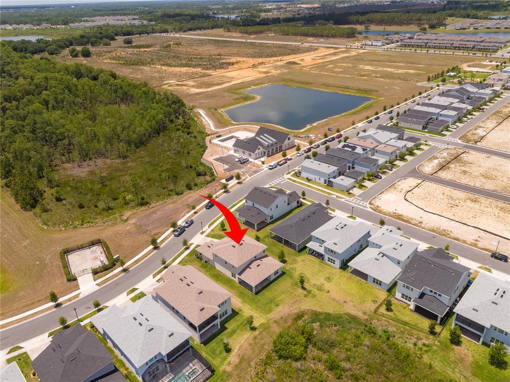 An aerial view shows a two-story house with a red arrow pointing to its roof — 13181 TOOLCROSS WAY, WINTER GARDEN, FL