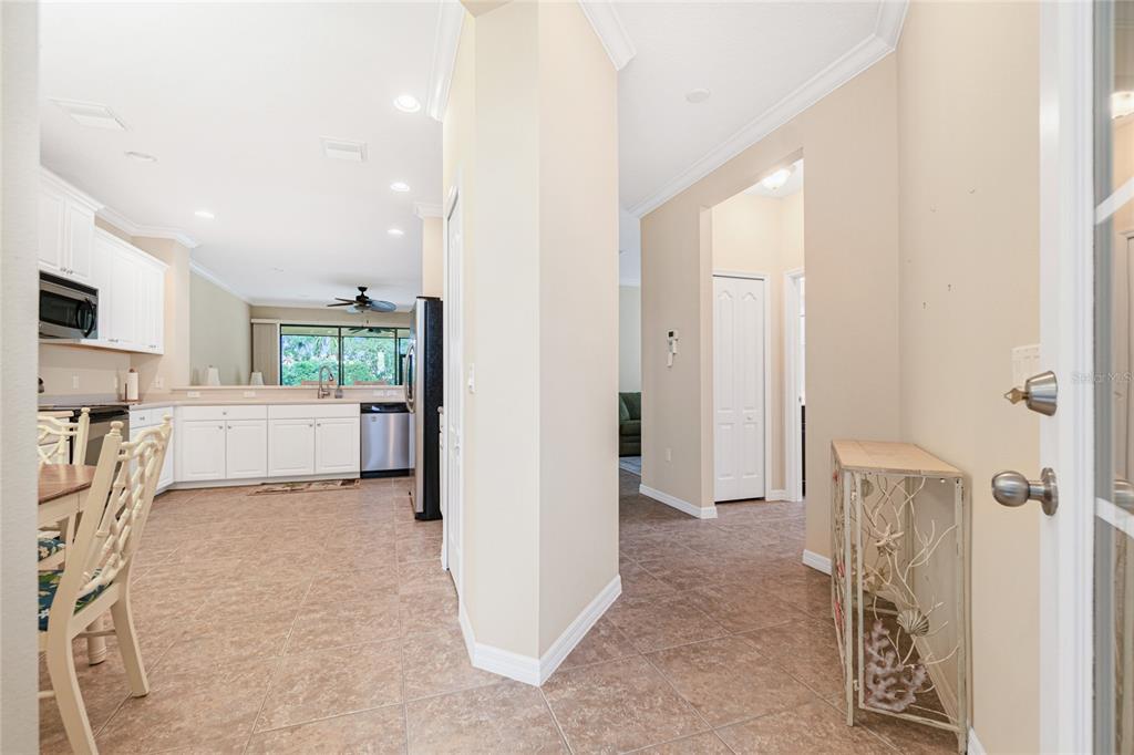A tiled entryway leads to an open kitchen with white cabinets and stainless steel appliances — 10924 LERWICK CIRCLE, ENGLEWOOD, FL